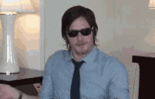 a man wearing sunglasses is sitting in a chair