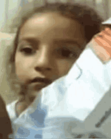 a close up of a little girl holding a piece of paper in her hand .