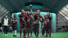 a group of football players wearing maroon uniforms with the number 42 on their chests