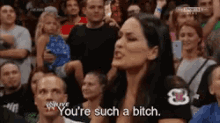 a woman in a crowd of people says you 're such a bitch
