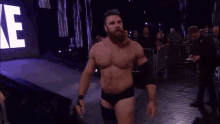 a man with a beard is walking into a wrestling ring with a sign that says jae