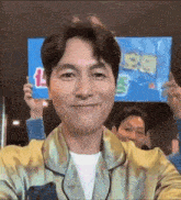 a man in a green jacket is holding a blue sign in his hands .