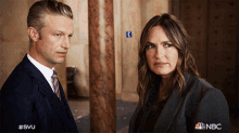 a man and a woman are standing next to each other and the nbc logo is visible in the corner