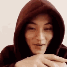 a close up of a person wearing a red hoodie and smiling .