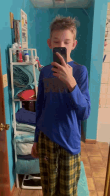 a young boy taking a selfie in a bathroom