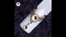 a woman 's nails are decorated with a necklace and rhinestones