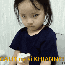 a little girl holding an ice cream cone with the words galit na si khianne written above her