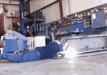 a man is welding a piece of metal in a garage with a machine that says jlg k2 on it