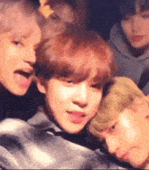 a group of young men are standing next to each other and one of them is sticking out his tongue .