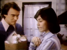 a man and a woman are standing next to each other in a room