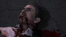 a man with blood coming out of his mouth is laying on the floor .