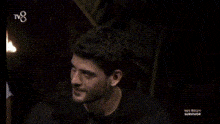 two men are standing next to each other in a dark room and smiling for the camera .