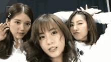 three girls are posing for a picture and one of them is wearing a mickey mouse sweatshirt