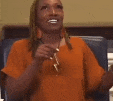 a woman is sitting in a chair with her hand to her chin .