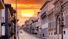 a sunset over a cobblestone street with a sign that says ' avenida ' on it
