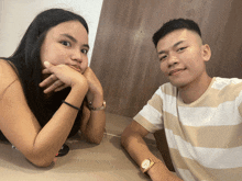 a man and a woman are sitting next to each other and the man has a watch on his wrist