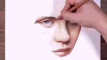 a person is drawing a close up of a man 's face with a pencil .