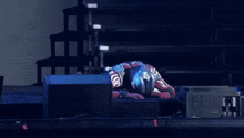 a man in a superhero costume is laying on the stage