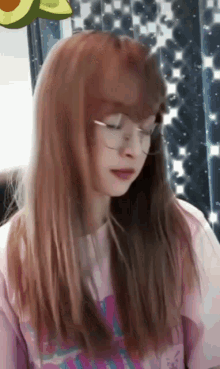 a girl wearing glasses and a pink shirt with avocado on her head
