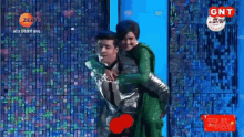 a man is carrying a woman on his back in front of a screen that says gt