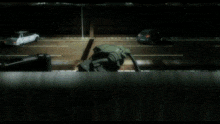 a robot is crawling on the ground with a briefcase in the background
