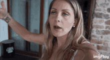 a woman is making a funny face in front of a coffee cup