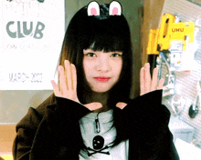 a girl making a face in front of a sign that says club on it