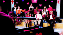 a group of people are sitting on a stage and one of them is saying " no "