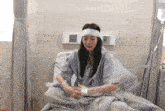 a woman in a hospital bed with a headband on her head