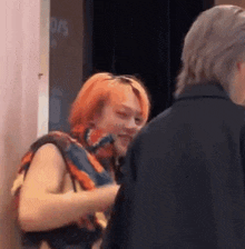 a man and a woman are standing next to each other in a room .