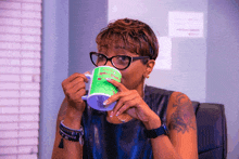 a woman is drinking from a green mug that says " you can do whatever you want " on it