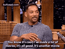a man is sitting in front of a microphone and talking about a movie .