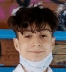 a young boy wearing a face mask is smiling .