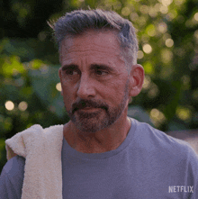 a man with a towel around his neck is wearing a netflix t-shirt