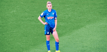 two female soccer players are standing on a field and one of them has the number 1 on her shirt .