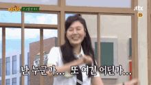 a woman in a school uniform is smiling in front of a window with korean writing on it