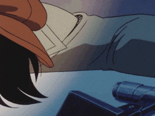 a person wearing a hat is laying on a table next to a telescope
