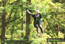 a woman is flying through the air on a zip line with the words mount hermon adventures below her