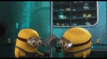 a couple of minions standing next to each other holding a hammer