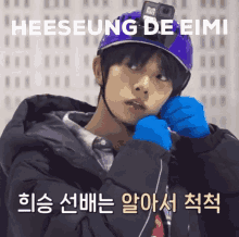 a young man wearing a purple helmet and blue gloves with the name heeseung de eimi written above him