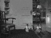 a black and white photo of a room with penguins and a chair