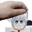 a person is petting a cat doll with a necklace .