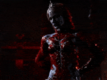a man is being attacked by a red monster in a dark room