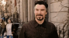 a man with a beard is walking down a street with his eyes closed .