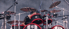 a man playing a set of drums with a shield on it