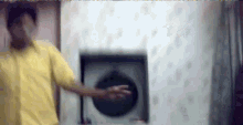 a man in a yellow shirt is dancing in front of a washing machine