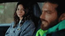 a man and a woman are sitting in the back seat of a car and smiling .