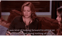 a woman is sitting on a couch looking forward to sitting on the couch and doing nothing all day
