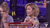 two women sitting in front of a sign that says " maripily regresa a la casa "