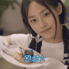a girl is holding a plate with a cake on it with a star in the corner